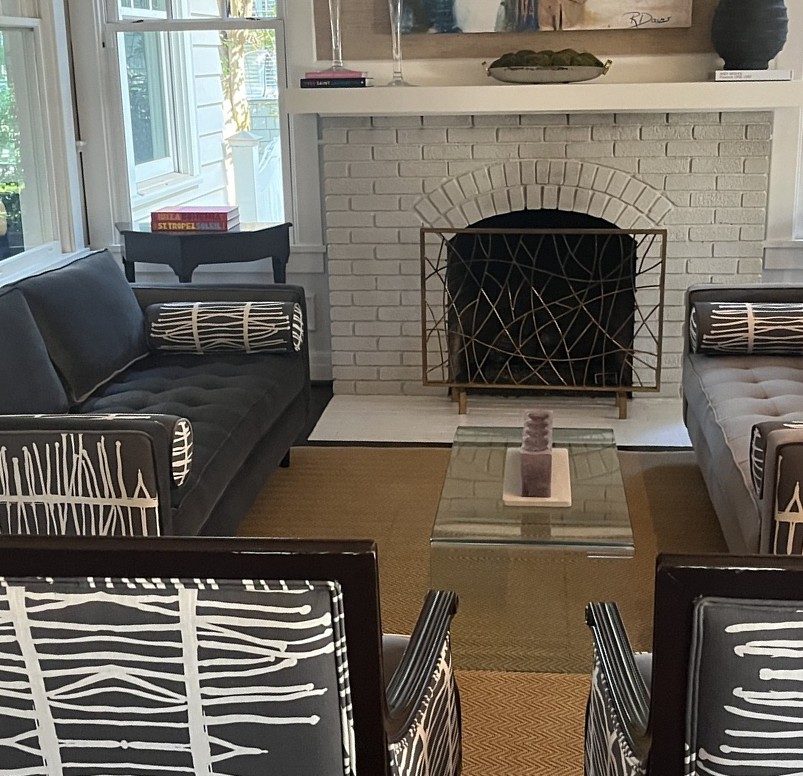 Black-and-white graphic chairs + settees, white-brick fireplace (straightened)