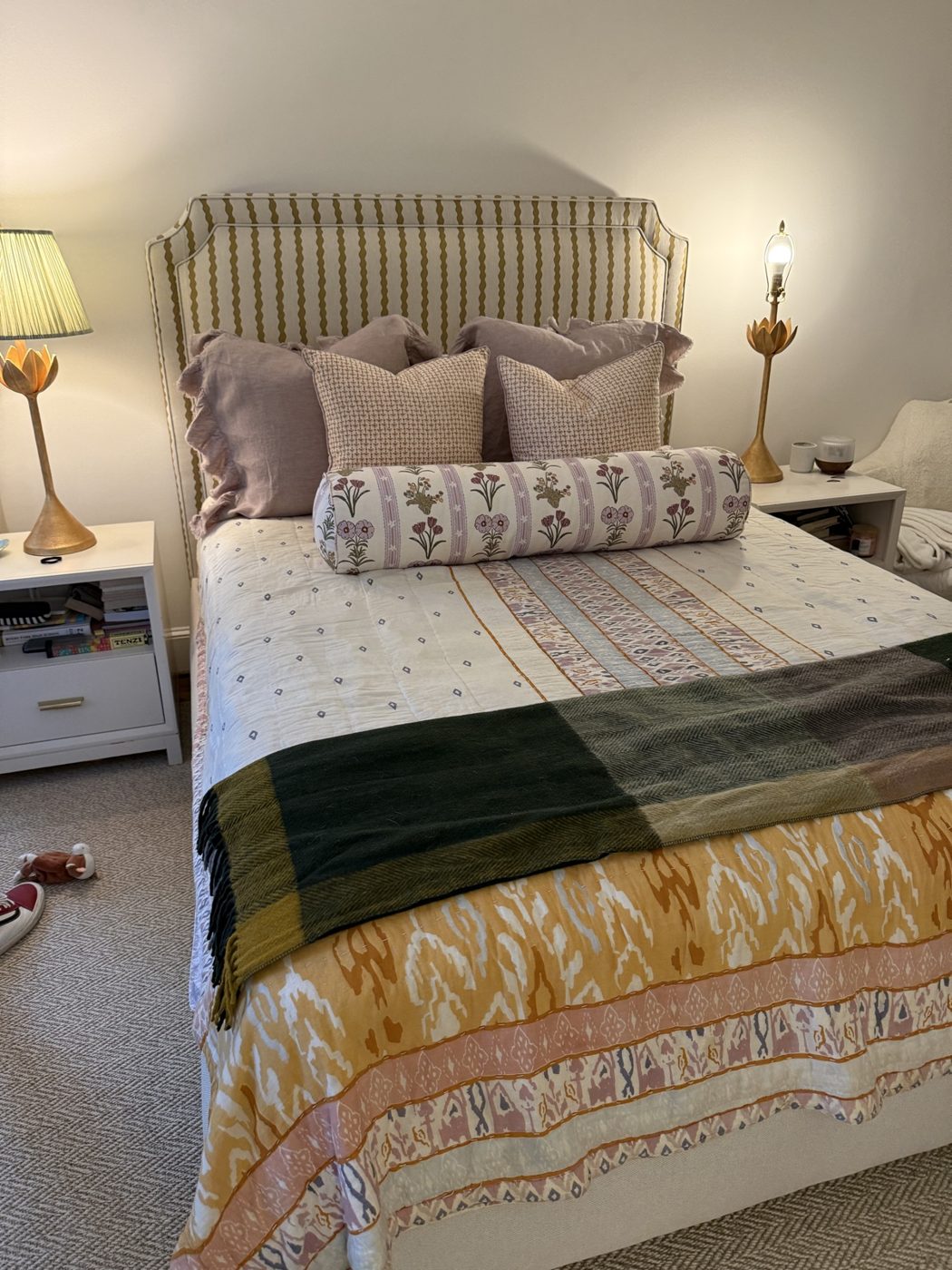 Striped headboard bed with gold lamps