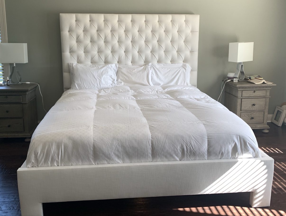White diamond-tufted bed, straight-on