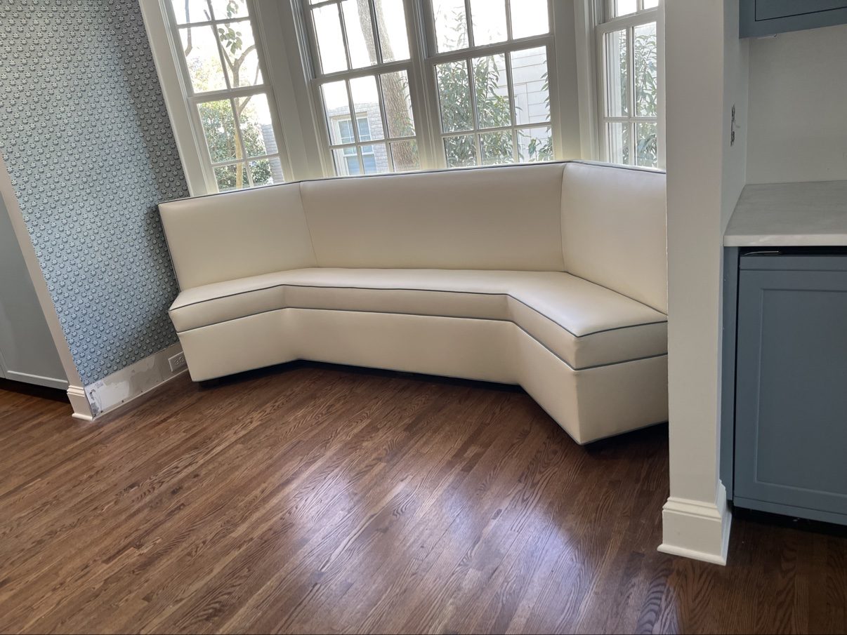 Cream curved corner banquette with navy piping