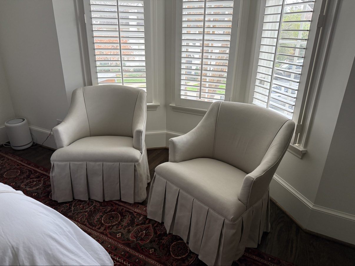 Cream skirted armchairs by bay windows