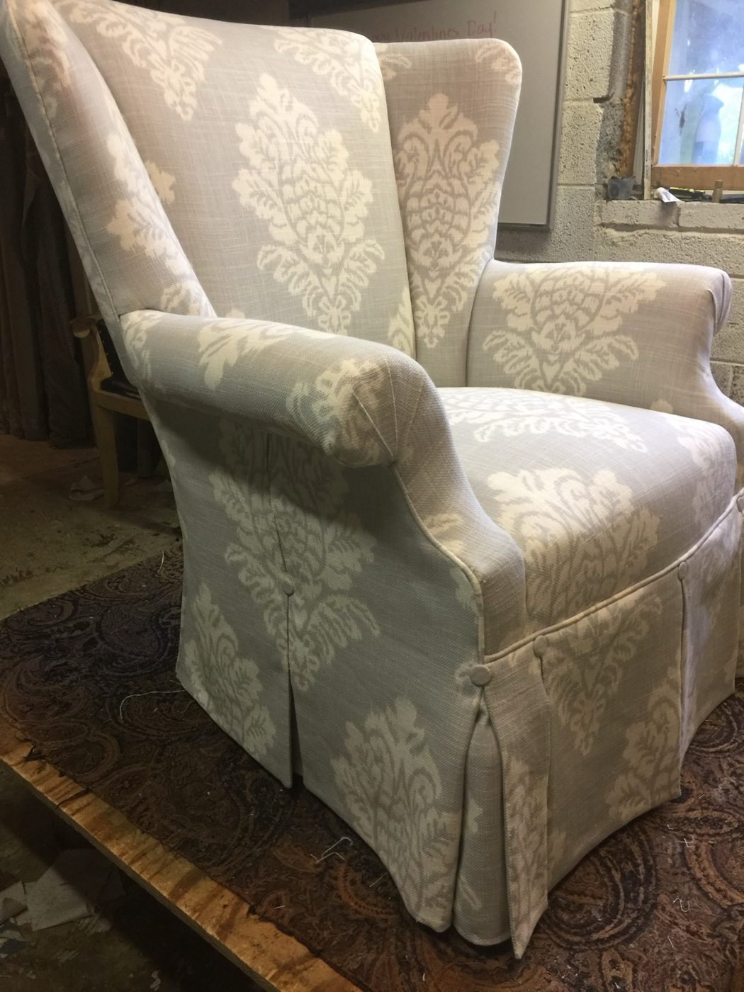 Gray damask skirted wingback chair