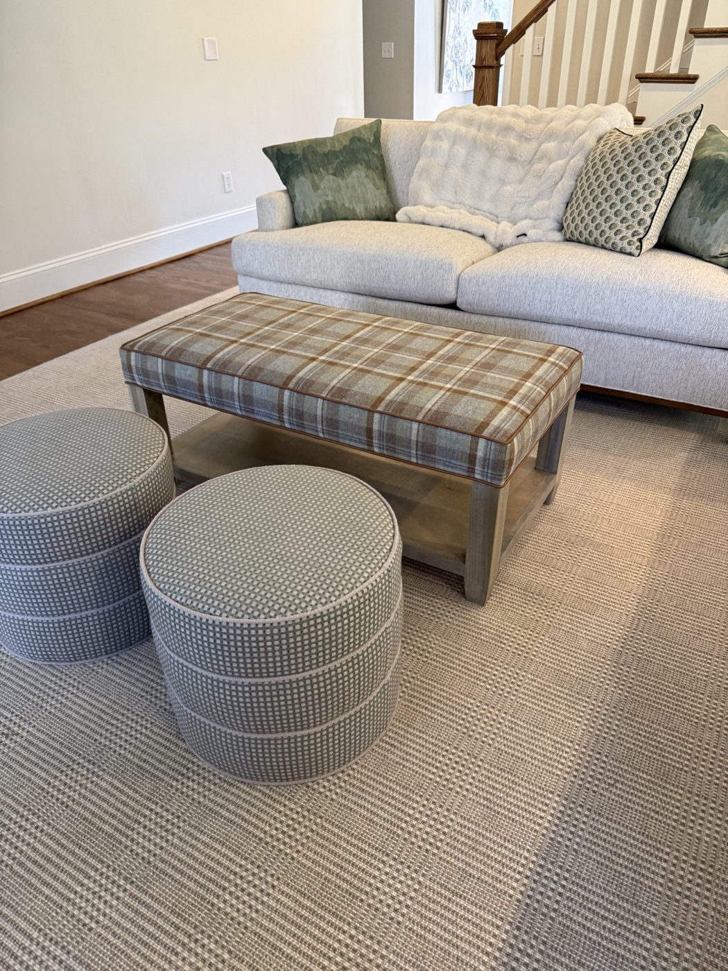 Living room: sofa, plaid ottoman, poufs
