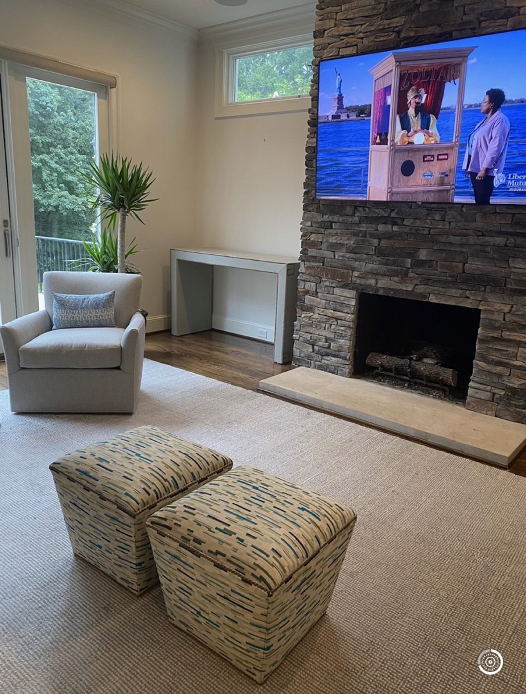 Living room with cube ottomans + stone fireplace (cropped from screenshot)