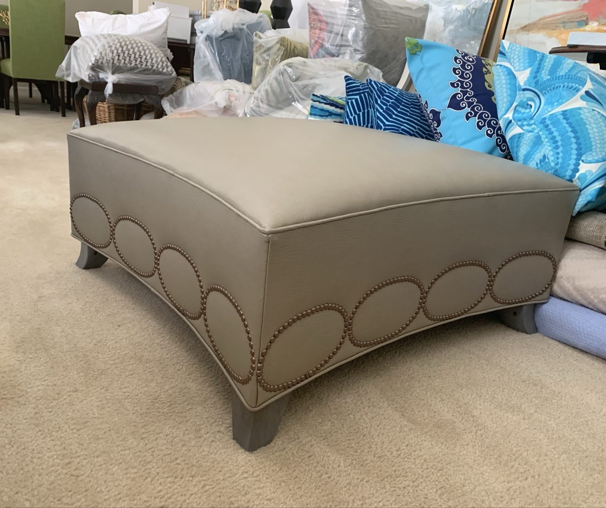 Taupe ottoman with nailhead ovals