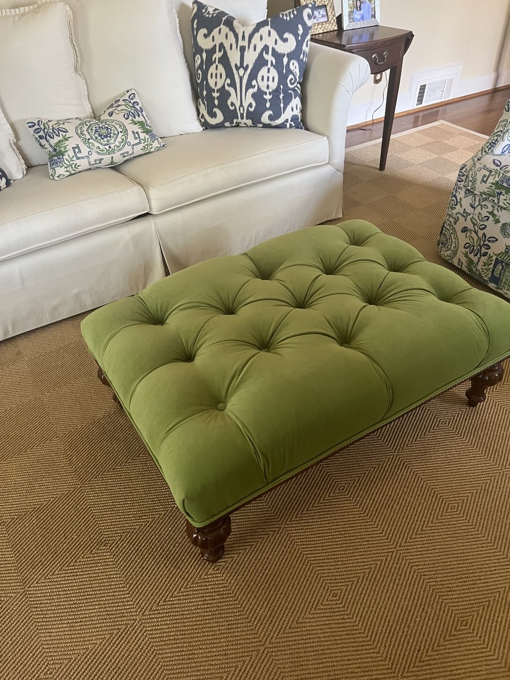 Green tufted ottoman with white sofa