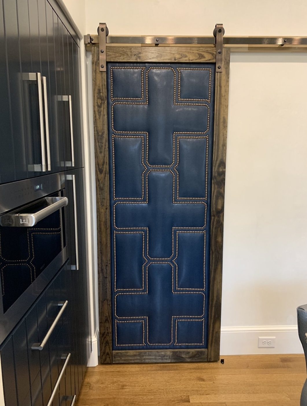 Blue barn door with geometric nailhead pattern (cropped from screenshot)