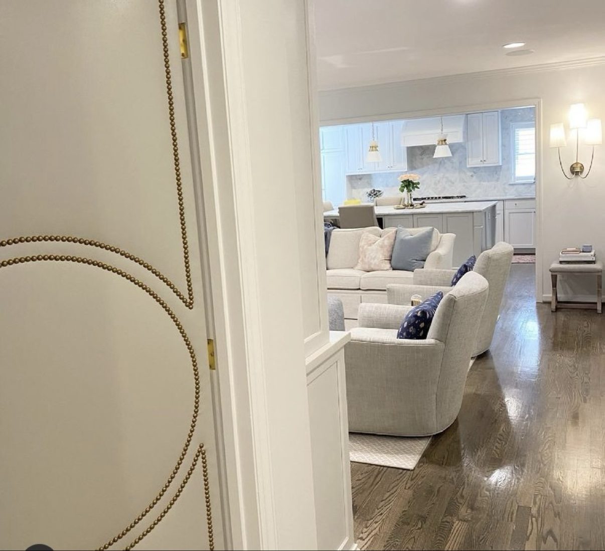Circle-motif door with brass nailheads, detail view into living room