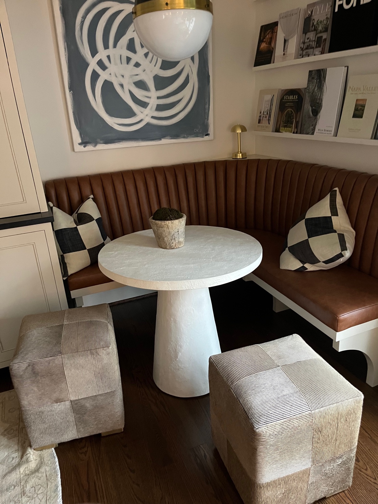 Brown leather channel-tufted corner banquette with upholstered cube ottomans