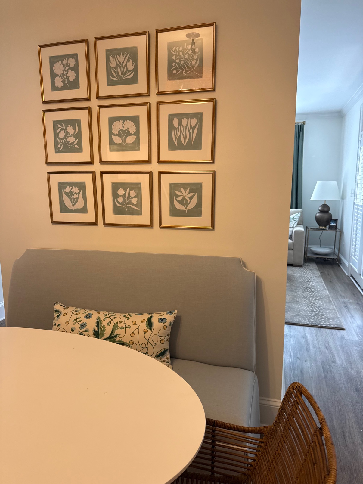 Light gray upholstered banquette bench with floral pillow in a breakfast nook