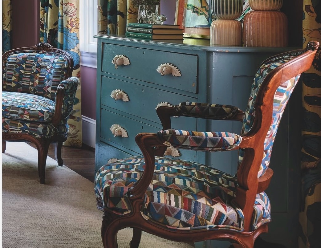 Carved wood armchairs reupholstered in colorful geometric fabric